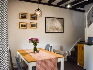 a dining room table with a vase of flowers on it at Caer Elen in Dolwyddelan