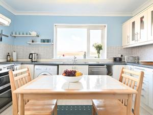 a kitchen with a table with a bowl of fruit on it at Taigh An Uillt in Tighnabruaich