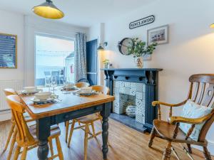 a dining room with a table and a fireplace at Tyr Llyr in Penclawdd