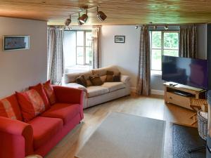 a living room with a couch and a flat screen tv at Shielside in Acharacle