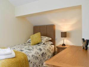 a bedroom with a bed and a table with a lamp at Tormire Laithe in Bell Busk