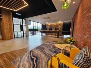 a living room with yellow furniture and a brick wall at Le'genda Hotel in Kajang