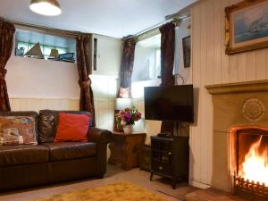 a living room with a couch and a fireplace at Ewden in Robin Hood's Bay