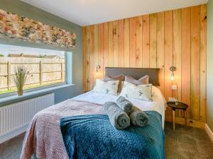 a bedroom with a bed with towels on it at Harebell Cottage in Addlethorpe