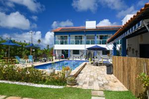 a house with a swimming pool in front of a house at Chalés Casuarinas in Japaratinga