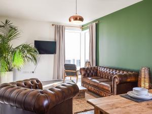 a living room with a leather couch and a table at Watersreach in Collieston