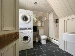 a bathroom with a washing machine and a toilet at Fishermans Cottage in Gardenstown