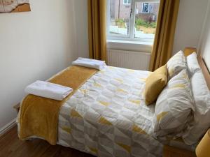 a bedroom with a bed with a quilt and a window at Paignton View in Paignton