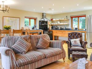 a living room with a couch and a kitchen at Over Brandelhow in Borrowdale