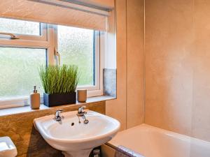 a bathroom with a sink and a tub and a window at Brookdale in Malpas
