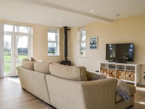 a living room with a couch and a flat screen tv at School Cottage in Lowthorpe