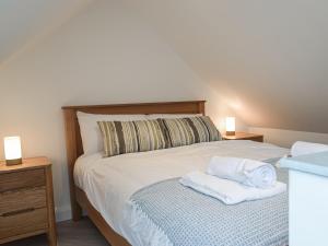 1 dormitorio con 1 cama con 2 toallas en Hafan Gwyn en Verwick
