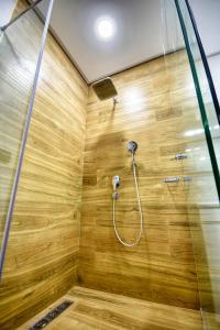 a bathroom with a shower with a wooden wall at Luxury Seafront Appartement 6-7p in Agadir +83 photos