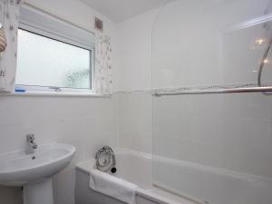 a white bathroom with a sink and a shower at Devon Court 2 in Salcombe