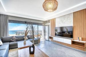 a living room with a couch and a large window at Luxury Seafront Appartement 6-7p in Agadir