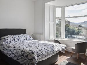 a bedroom with a bed and a large window at Ty Isaf in Barmouth