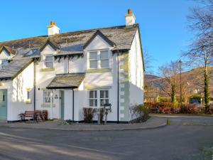 a white house on the side of a street at Wise Cottage in Keswick