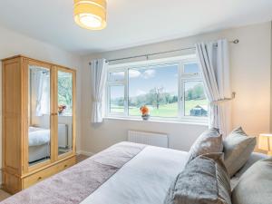 a bedroom with a bed and a large window at Carr View Farm in Bamford