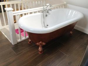 a bath tub in a bathroom next to a crib at The Potting Shed in Preston Wynne