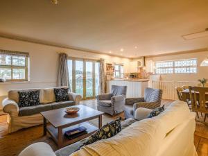 a living room with couches and a table at Ladybird Cottage in Hunstanton