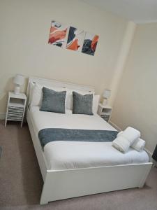 a white bed in a white room with two lamps at Charter House with good Wifi in Chatham