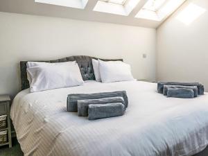 a large white bed with three pillows on it at Willow Cottage - Uk38484 in Saltash