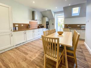 a kitchen with a wooden table and chairs at Thornbank in Millport