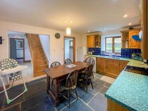 a large kitchen with a wooden table and chairs at Cefn Y Meirch in Bala