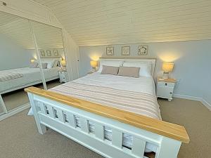 1 dormitorio con 1 cama grande y espejo en Thornbank, en Millport