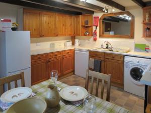 a kitchen with a table with plates and glasses on it at Breacwell Cottage in Bonar Bridge