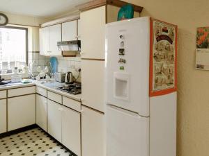 uma cozinha com armários brancos e um frigorífico em Delfryn em Pen-y-groes