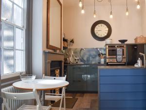 cocina con mesa y reloj en la pared en Garden Flat en Ryde