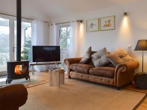 a living room with a couch and a fireplace at Chapelburn in Lawers