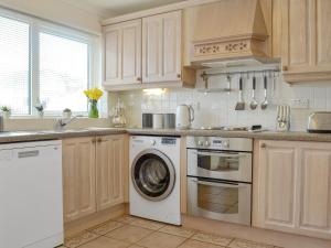 a kitchen with a washing machine and a dishwasher at Stepping Stones in Trearddur