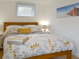 a bedroom with a bed with a comforter on it at Stepping Stones in Trearddur