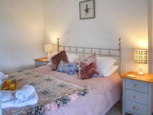 a bedroom with a bed with pillows and two lamps at Bryn Melyn - Uk6518 in Frongoch