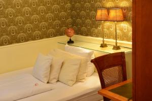 科隆的住宿－多姆斯特恩酒店，一张带白色枕头的床和一张带两盏灯的桌子