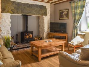 a living room with a table and a fireplace at Bryn Melyn - Uk6518 in Frongoch