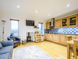 sala de estar con sofá y cocina en Riof Ocean Cottage - Uk7125, en Valtos