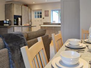 a kitchen and living room with a table and chairs at Hafod Y Bryn in Benllech