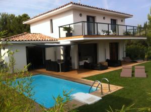 une villa avec une piscine en face d'une maison dans l'établissement Le Hameau de la Crique de l'Anglaise, à Bandol