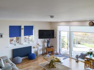 a living room with a tv and a glass table at 4 Dolphins in Connel