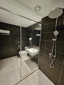 a bathroom with a shower and a toilet and a sink at Le'genda Hotel in Kajang +24 photos