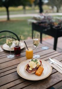 a plate of food on a wooden table with wine glasses at Balgownie Estate Bendigo in Bendigo