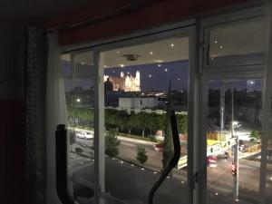 una ventana con vistas a la ciudad por la noche en Habitacion privada en Centro Lopez Mateos con Aire Acondicionado Oficina Estacionamiento en León