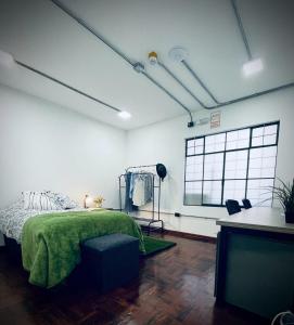 ein Schlafzimmer mit einem grünen Bett und einem Fenster in der Unterkunft Idea Home in Lima