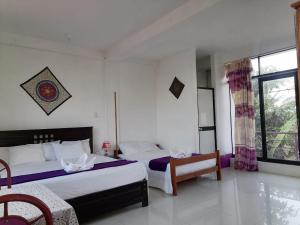 a bedroom with two beds and a window at Chimicuas House in Puerto Maldonado