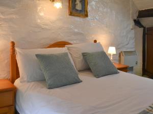 un letto bianco con due cuscini sopra di Ceunant a Aber Cowarch