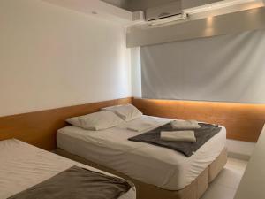 two beds in a small room with a window at Real Apartments 255 - High level Copacabana 2 bedrooms close to Ipanema in Rio de Janeiro