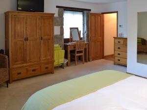 1 dormitorio con 1 cama, vestidor y escritorio en Eglos Derry Farm Cottage - E4597 en Cury